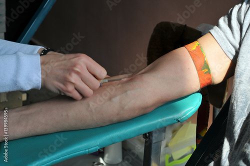 Nurse pierces arm vein with needle blank tube