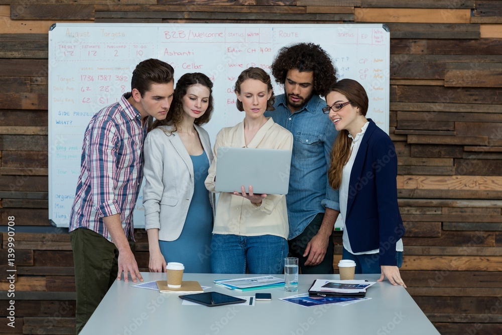 Business team discussing over laptop in meeting Business team discussing over laptop in meeting