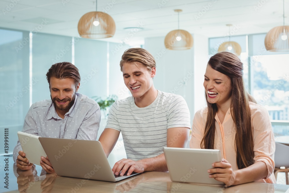 Happy executives using digital tablet and laptop Happy executives using digital tablet and laptop