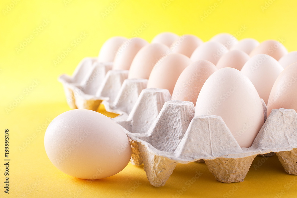 Eggs in a box on a yellow background Eggs in a box on a yellow background