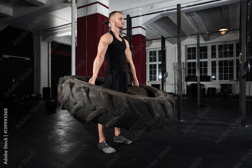 Obraz premium Man Doing Exercise With Tire