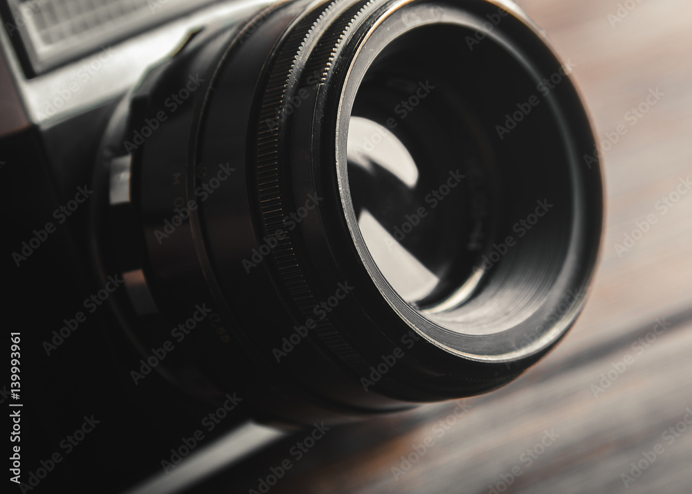 Vintage film camera lens on wooden table. Close up.