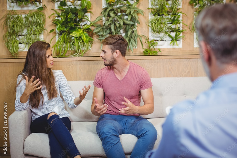 Couple arguing in counseling session with a doctor Couple arguing in counseling session with a doctor