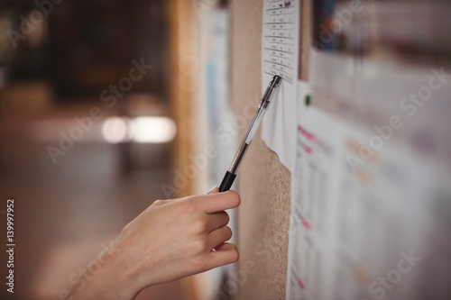 Schoolgirl looking at notice board in corridor photo