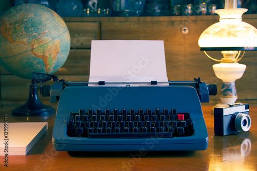 traveler ready for writing a book, retro typewriter and camera in antique wooden living room, vintage style  photo