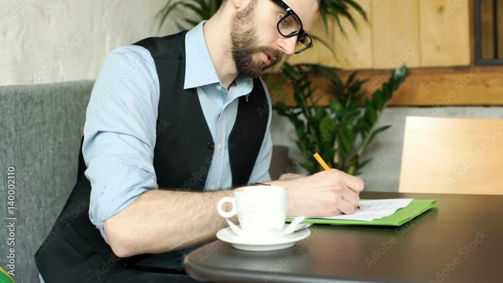 Businessman reading some contract and writing on it, steadycam shot
Businessman reading some contract and writing on it, steadycam shot