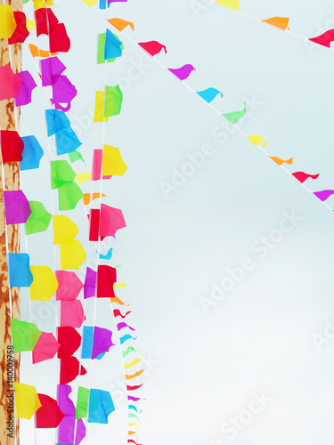 Garlands of bright multicolored flags against the sky. Vertical and diagonal arrangement of flags
