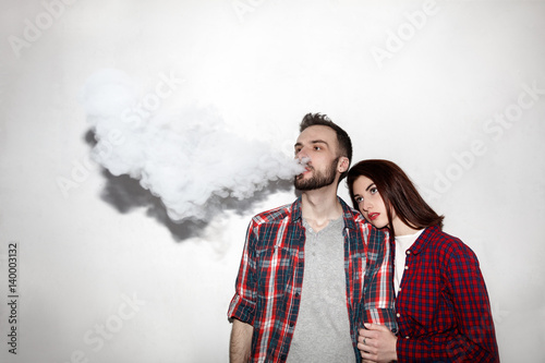 a man and woman smoking electronic cigarette vape
