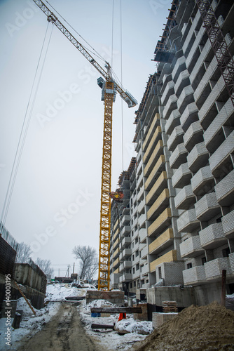 Construction site, a crane working on the construction site, the construction of high-rise apartment house