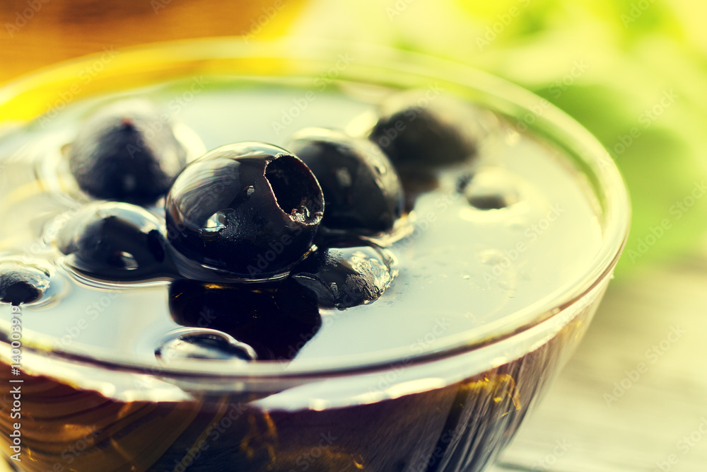 Fresh tasty beautiful black olives with olive oil on bowl on bright background. Fresh tasty beautiful black olives with olive oil on bowl on bright background.