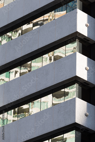 Building reflected on shiny glass wall