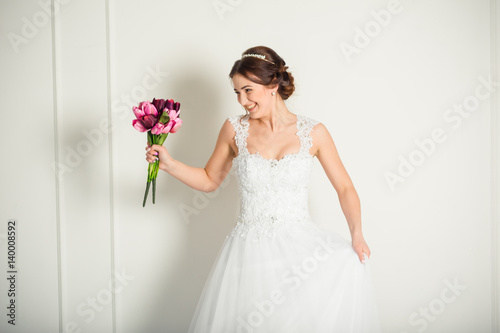 Smiling bride holding big wedding bouquet