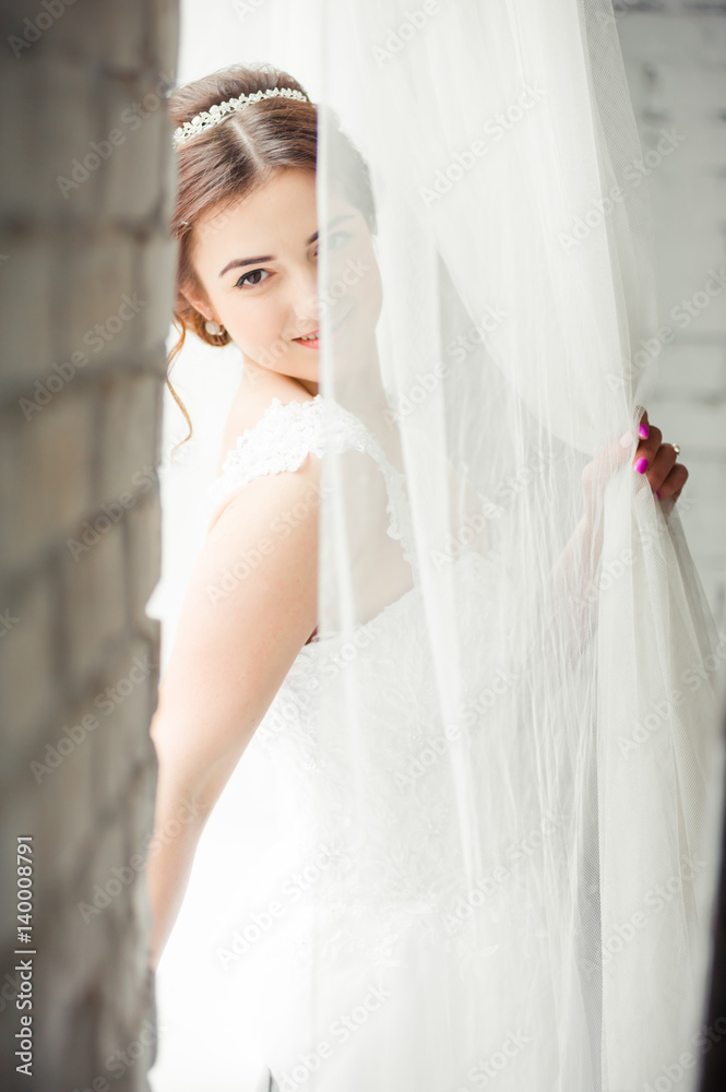 Beautiful bride with bouquet before wedding ceremony near window Beautiful bride with bouquet before wedding ceremony near window