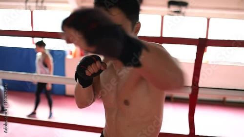 POV of male asian boxer throwing punches towards the camera in a boxing ring