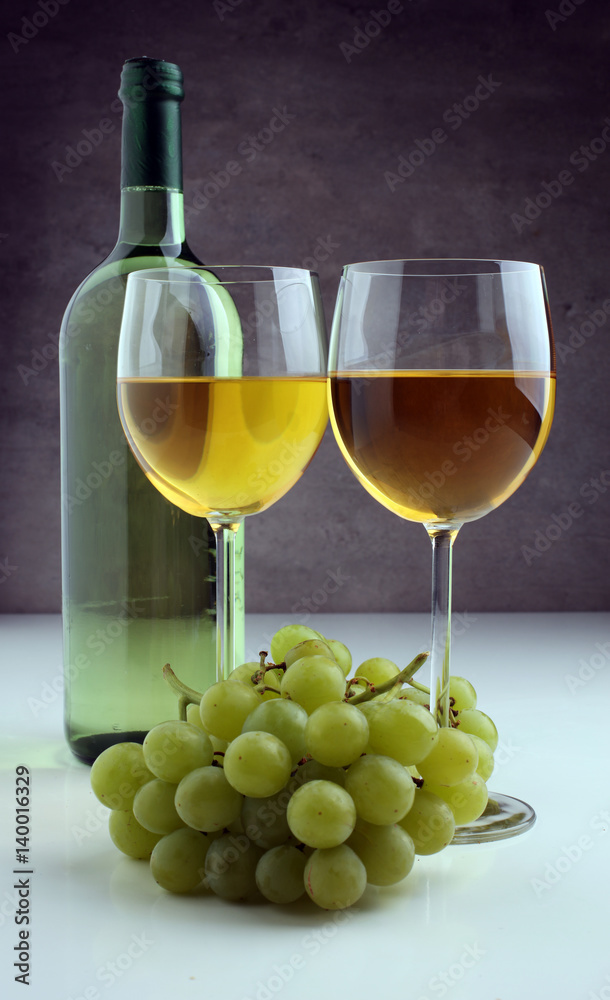 Bottle of white wine, grape on wooden table Bottle of white wine, grape on wooden table