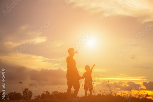 Father took the baby learn to walk at sunset. © Chittakon