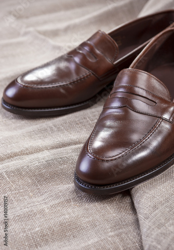 Shoes Concepts and Ideas. Closeup of Stylish Modern Brown Leather Penny Loafer Shoes On Mesh Surface.