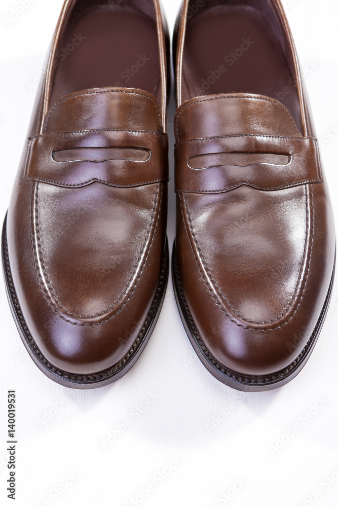 Footwear Concepts. Pair of Stylish Brown Penny Loafer Shoes Against White Background. Placed Together Closely Footwear Concepts. Pair of Stylish Brown Penny Loafer Shoes Against White Background. Placed Together Closely