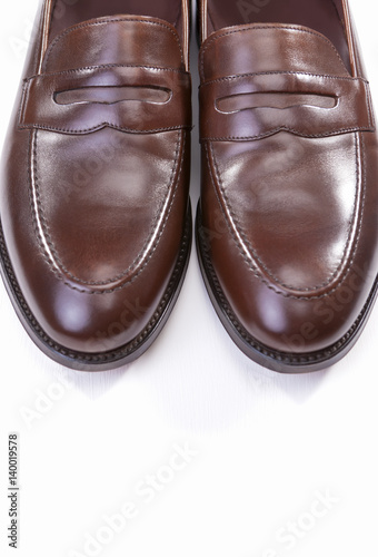 Footwear Concepts. Pair of Stylish Brown Penny Loafer Shoes Against White Background. Placed Together Closely.
