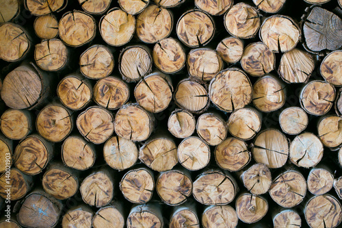 Natural wooden background - closeup of chopped firewood. Firewood stacked and prepared for winter Pile of wood logs