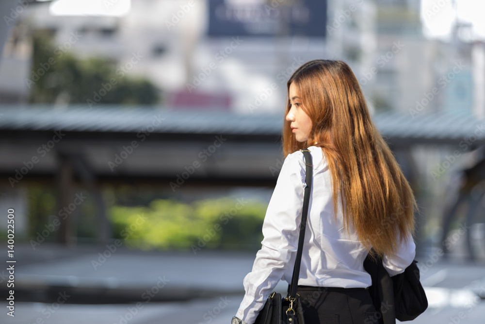 Fototapeta premium Back view of standing beautiful blonde business woman, backside view of person in modern city