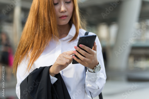 Business woman hands with smart phone in modern city
