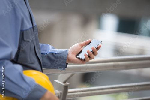 Engineer, Foreman hands with smart phone in modern city