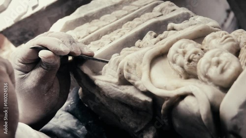 Hands of an latin expert craftsman, stone sculpting with chisel and hammer. Slow motion
