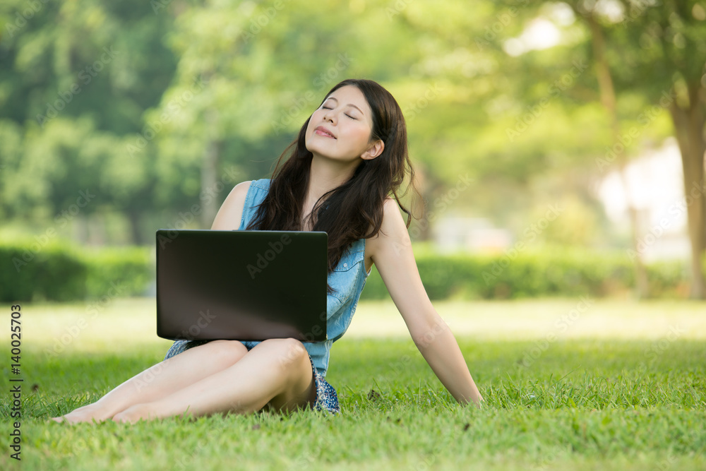 beautiful asian woman using computer in outdoor park