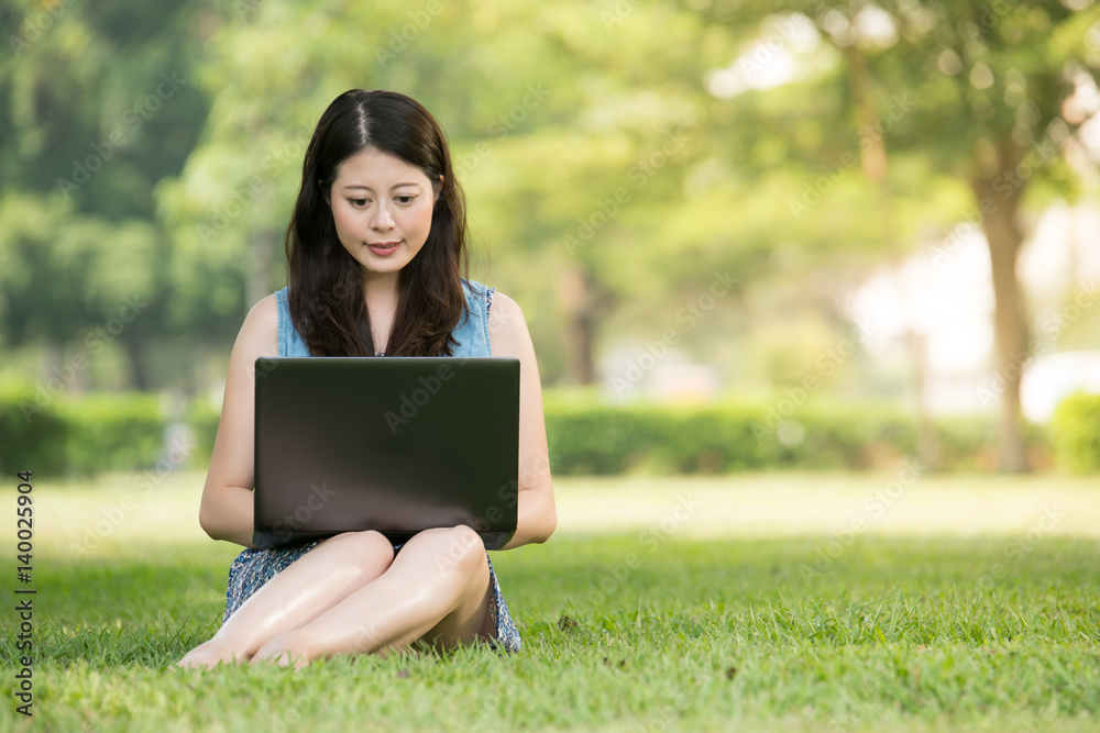 beautiful asian woman using computer in outdoor park