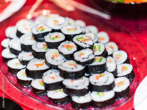 A plate full with sushi rolls.
