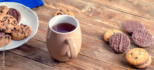 Cup of tea and cookies on a wooden table.