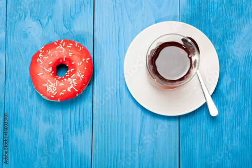 Cup of tea and donuts on a blue wooden table