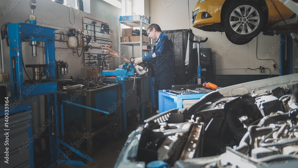 Manual labor small business - workshop - male caucasian mechanic worker works with circular saw Manual labor small business - workshop - male caucasian mechanic worker works with circular saw