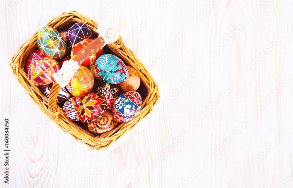 Easter eggs in a basket on white table.