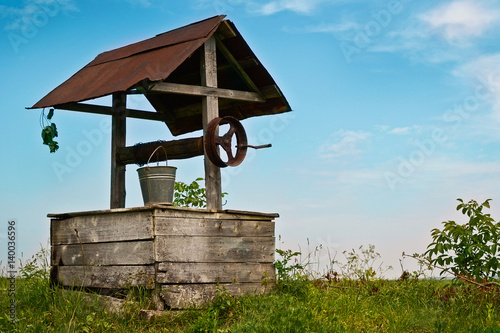 Old wooden well in the field photo