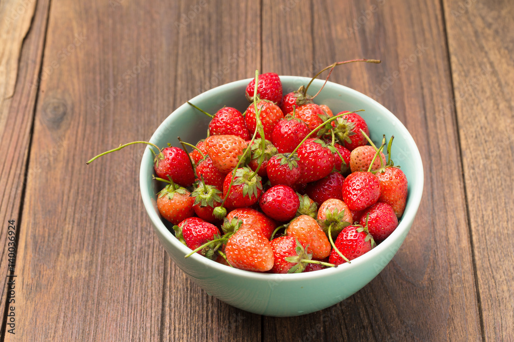 Fresh ripe strawberries in small green bowl on wooden. Fresh ripe strawberries in small green bowl on wooden.