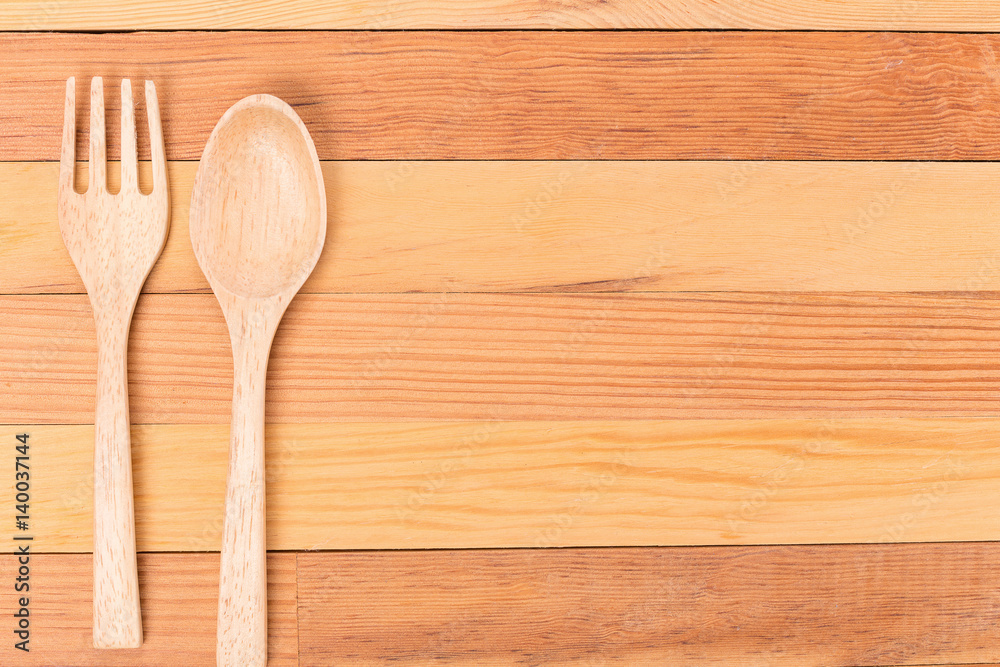 Top view of wooden fork and spoon on light wooden background. Top view of wooden fork and spoon on light wooden background.