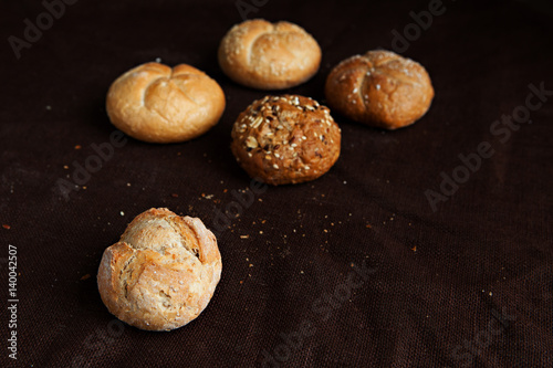variety of small breads with seeds isolated on black background