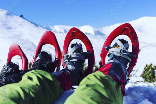 Winter hiking in the mountains on snowshoes with a backpack and tent.