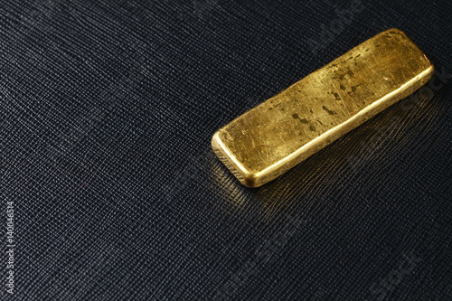 The gold bar put on the dark background represent gold and business finance concept related idea.