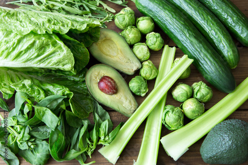 Products containing folic acid - B9 vitamin . Green vegetables on wooden background. Celery, arugula, avocado, Brussels sprouts, basil, cucumber, romaine salad