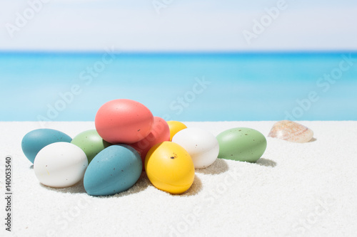 Easter on tropical beach background. Eggs on the white sand. Vacation and travel concept