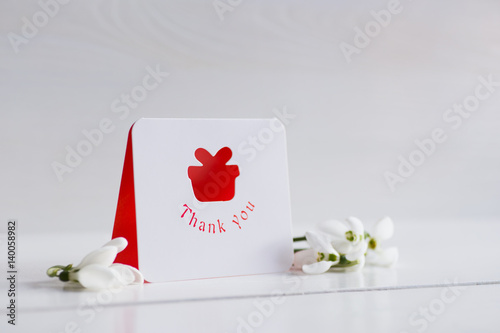 Beautiful white snowdrops with greeting card on white background
