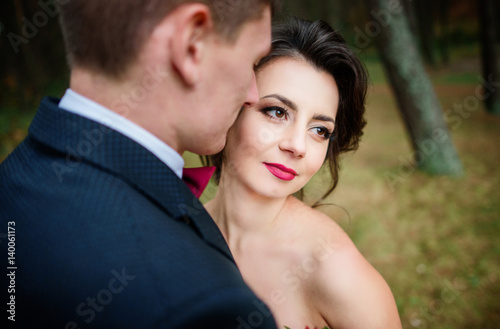 Tender touches of wedding couple hugging in the forest © IVASHstudio