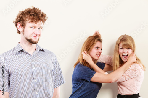 Aggressive mad women fighting over man.