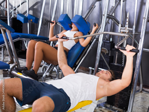 Man lifting heavy weights in press photo