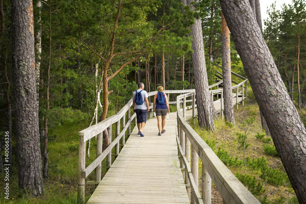 Couple walk on wooden deck in the wood with observation decks. Couple walk on wooden deck in the wood with observation decks.