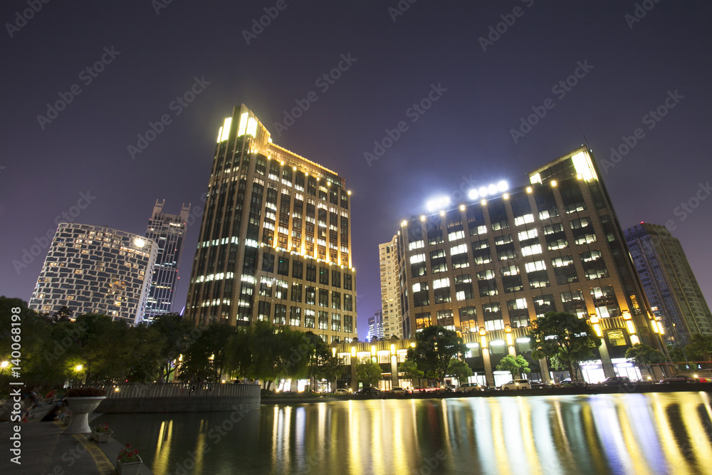 Obraz premium modern buildings near river at night