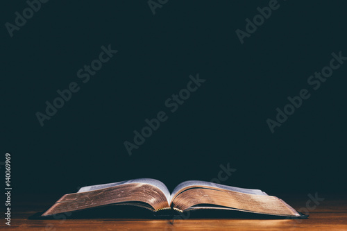 Foto Bible open on black background